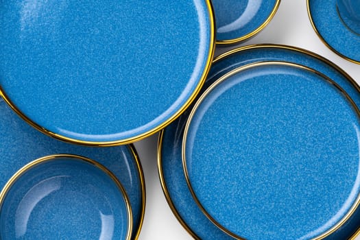 A set of blue ceramic plates on a white background. Top view