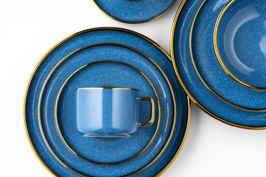 A set of blue ceramic plates and cup on a white background. Top view