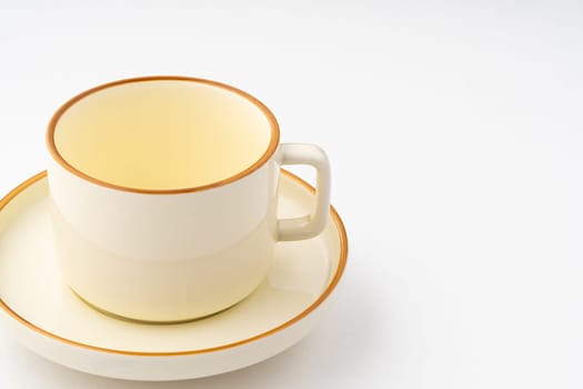 A set of white and brown ceramic plate and cup on a white background