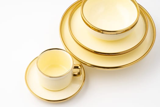 A set of golden luxury ceramic kitchen utensils on a white background