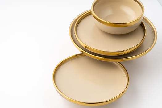 A set of light brown ceramic plate and bowl on a white background