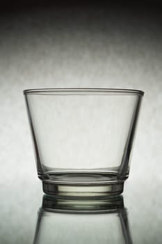 A vertical shot of an empty glass on a grey background