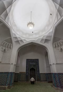 A man praying in the mosque in Samarkand, Uzbekistan