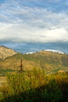 A vertical shot of mountains against the background of the cloudy sky. Central Asia