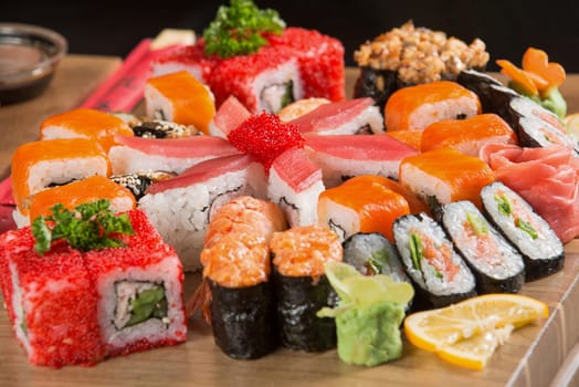 A closeup shot of a sushi set on a wooden plate