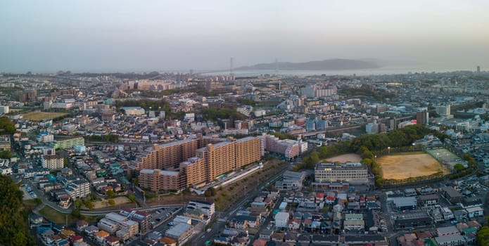 Aerial view of Akashi City buildings and bridge to Awaji Island at sunset. High quality photo