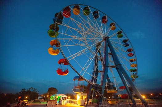 A attraction ferris wheel in the amusement park at night