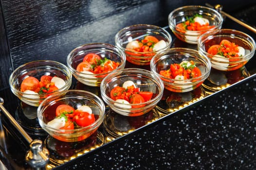 A closeup shot of a set of tomato salads in small bowls on a tray