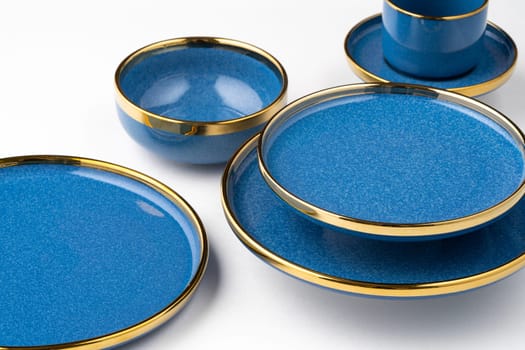 A set of blue ceramic plates and cup on a white background