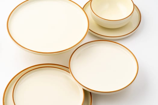 A set of white and brown ceramic plate and bowl on a white background