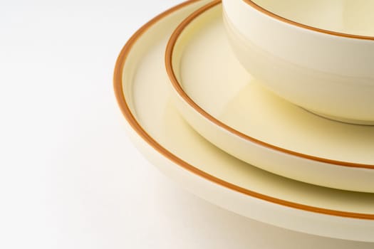 A set of white and brown ceramic plate and bowl on a white background. Close-up