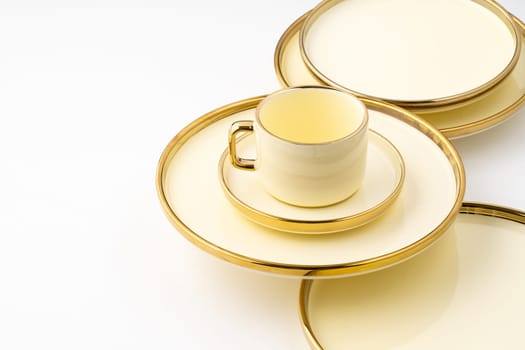 A set of golden luxury ceramic kitchen utensils on a white background