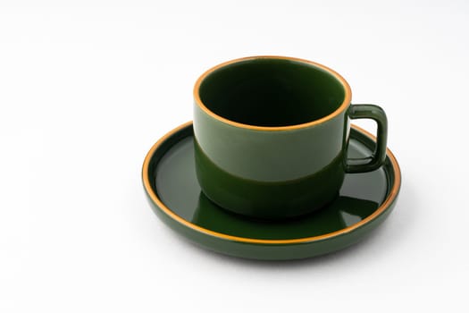 A set of green ceramic plate and coffee mug on a white background