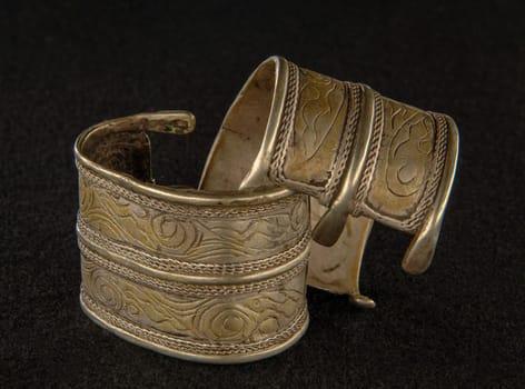 An antique bracelet with engraving isolated on a black background