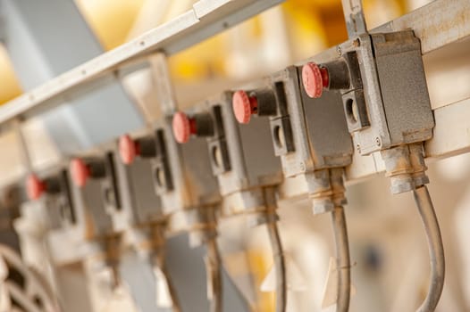 A closeup of a line of industrial pumps with blurred background