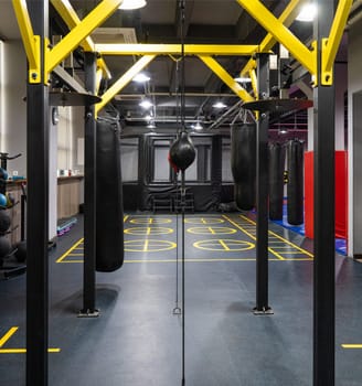 A vertical shot of boxing bags in the sports complex