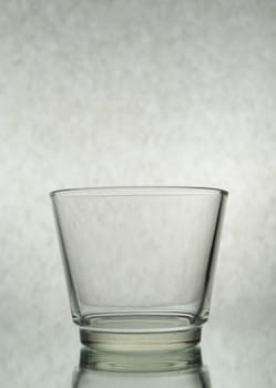 A vertical shot of an empty glass on a grey background