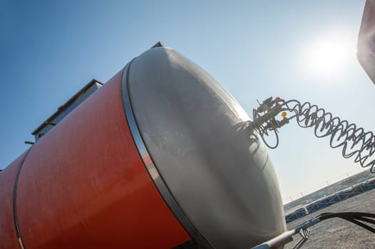 A closeup of a red gas tank on an industrial construction site