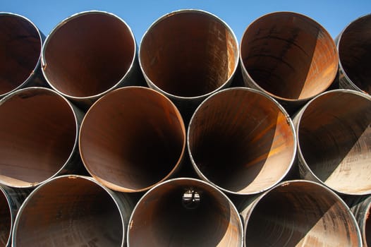 A line of oilfield large streel pipes, front view