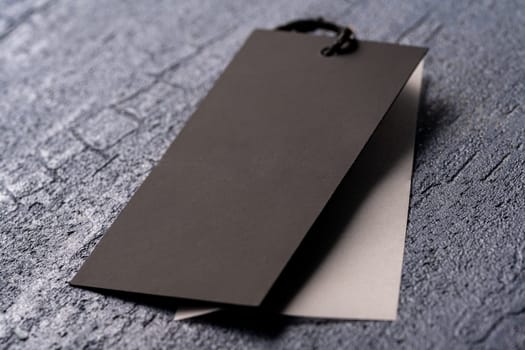 A closeup shot of a blank black clothing tag on a string for a price label on a cloth