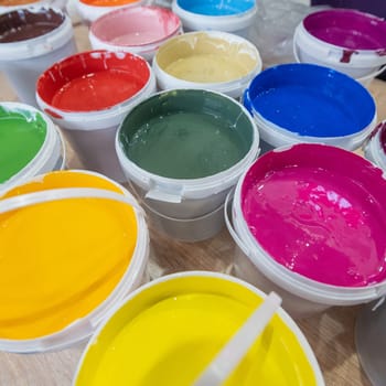 A closeup shot of buckets of colorful paint in a warehouse