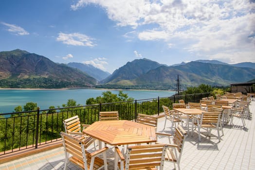 A beautiful shot of outdoor cafe seats near the shore on a resort in the mountains of Central Asia