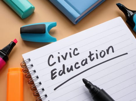 An Open notebook with words civic education and marker.