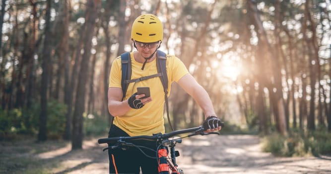 Cyclist checking route on smartphone during ride in forest