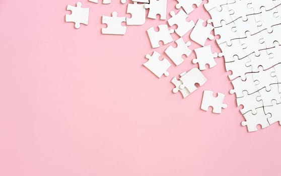 white puzzle pieces on pink background with copyspace
