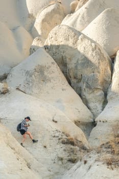 Woman tourist hiking on sandstone mountains in Cappadocia, Turkey