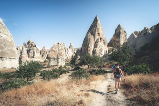 Rear view of tourist going to cave dwellings in Cappadocia, Turkey