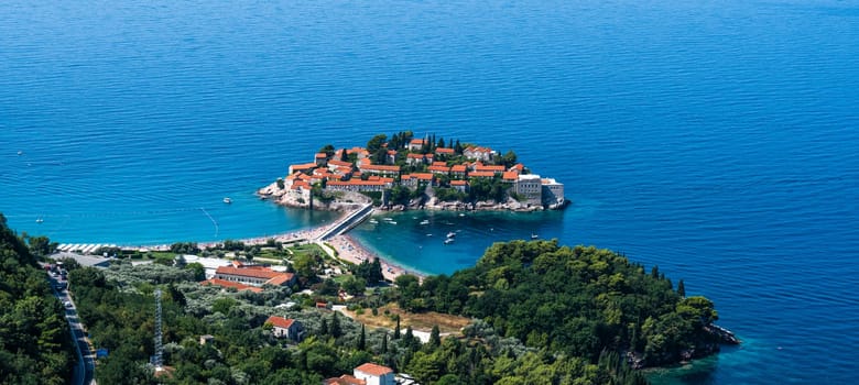 Sveti Stefan island in Montenegro from above. Scenic view on adriatic sea and luxury resort from mountains