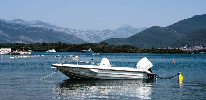 Boat in Adriatic sea, Montenegro with mountains on background. Sailboat transportaition in beautiful Mediterranean nature in sunny day