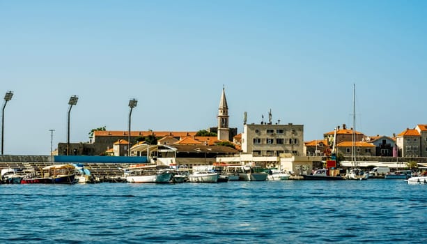 Mediterranean pier with yachts and boats in Montenegro, view from Adriatic sea. Balkan city with ships in sunny day