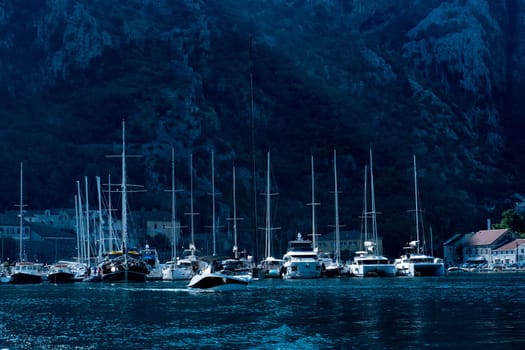 Yachts with mountains view in evening in Montenegro. Luxury boats harbour in Adriatic sea