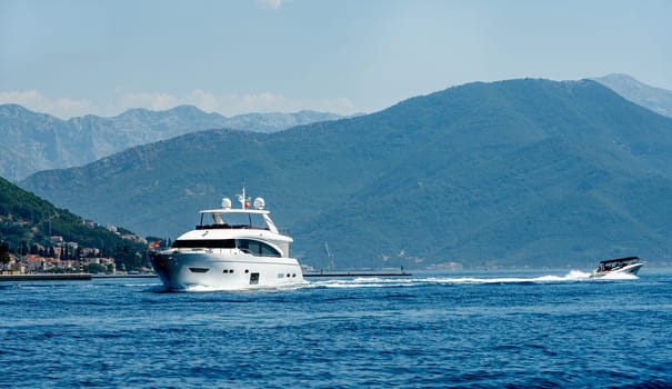 Luxury boat yacht in Adriatic sea in Montenegro with scenic mountains view. Amazing landscapes of balkans and sailing transport