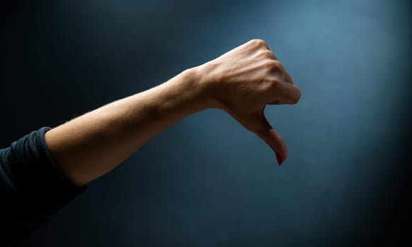 Hand shows sign holding finger down. Concept of gesture communication with visual symbols