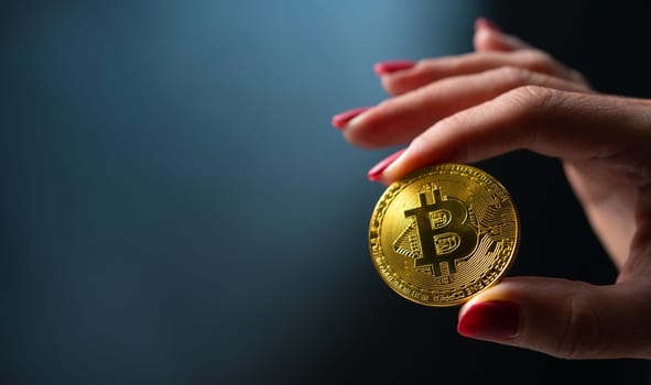 Female hand holding golden bitcoin virtual currency coin. Digital cyberspace money of future and symbol of mining