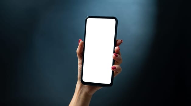 Hand holding smartphone with white copy space on screen. Female person with modern mobile cell phone and digital technology