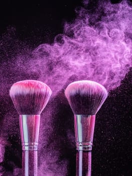 Cosmetics brush and explosion colorful makeup powder background - beauty make-up product and mineral cosmetic