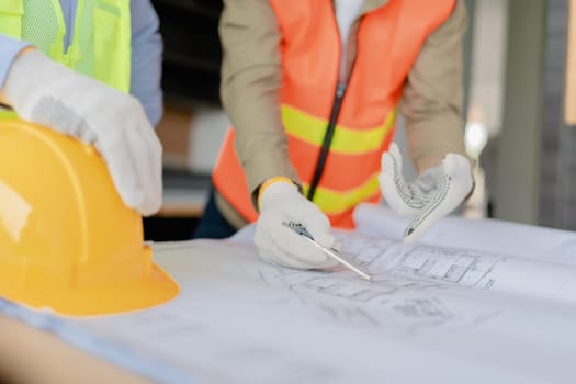 multi ethnic engineer brainstorming and measuring for cost estimating on paperworks and floor plan drawings about design architectural and engineering for houses and buildings.