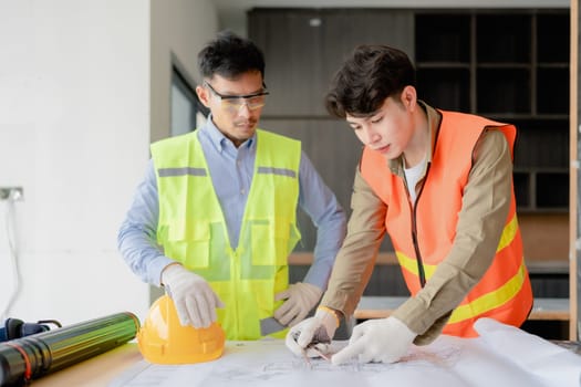 multi ethnic engineer brainstorming and measuring for cost estimating on paperworks and floor plan drawings about design architectural and engineering for houses and buildings.