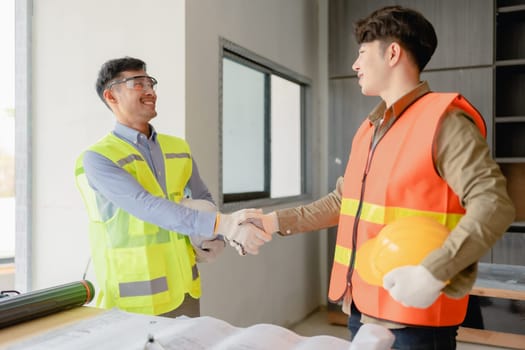 multi ethnic engineer brainstorming with deal and measuring for cost estimating on paperworks and floor plan drawings, contract and agreement concepts.