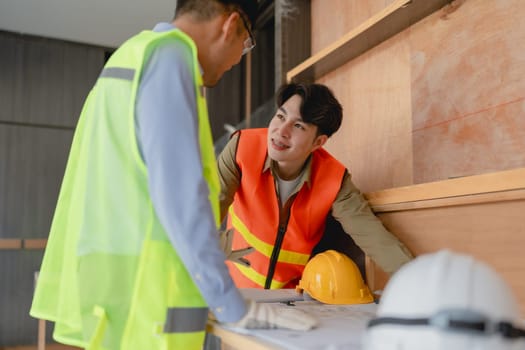 multi ethnic engineer brainstorming and measuring for cost estimating on blueprint and floor plan drawings about design architectural and engineering for houses and buildings.