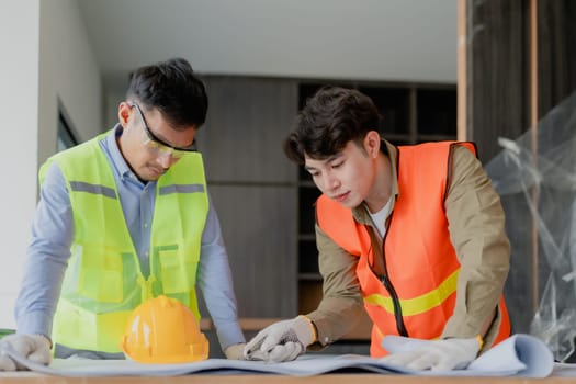 multi ethnic engineer brainstorming and measuring for cost estimating on paperworks and floor plan drawings about design architectural and engineering for houses and buildings.