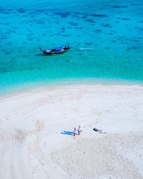 couple of men and women on the beach of Ko Lipe Island Thailand. drone aerial view of a sandbank in the ocean