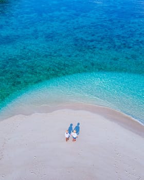 couple of men and women on the beach of Ko Lipe Island Thailand. drone aerial view of a sandbank in the ocean