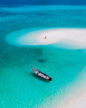 couple of men and women on the beach of Ko Lipe Island Thailand. drone aerial view of a sandbank in the ocean on a sunny day