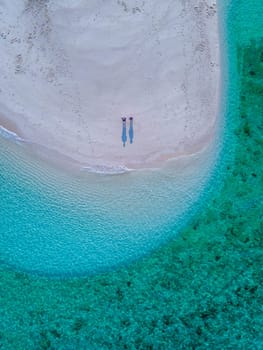 couple of men and women on the beach of Ko Lipe Island Thailand. drone aerial view of a sandbank in the ocean