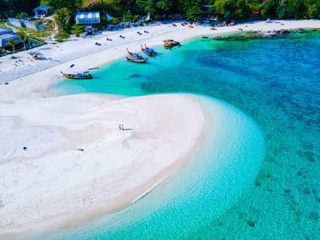 couple of men and women on the beach of Ko Lipe Island Thailand. drone aerial view of a sandbank in the ocean